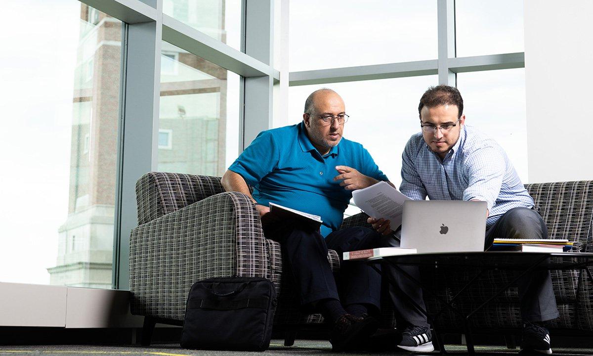 Two men sitting with a laptop